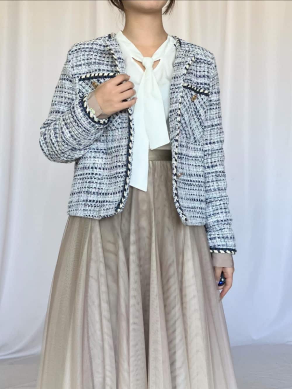 ホワイト系のシャツ/ブラウス、ゴールド系のスカート、ブルー系のパンプスを着用したレディースの冬コーディネートの5枚目の写真