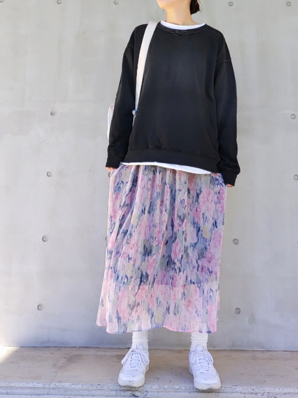 ブルー系のスカート、ホワイト系のスニーカー、ブラック系のスウェットを着用したレディースの冬コーディネートの2枚目の写真