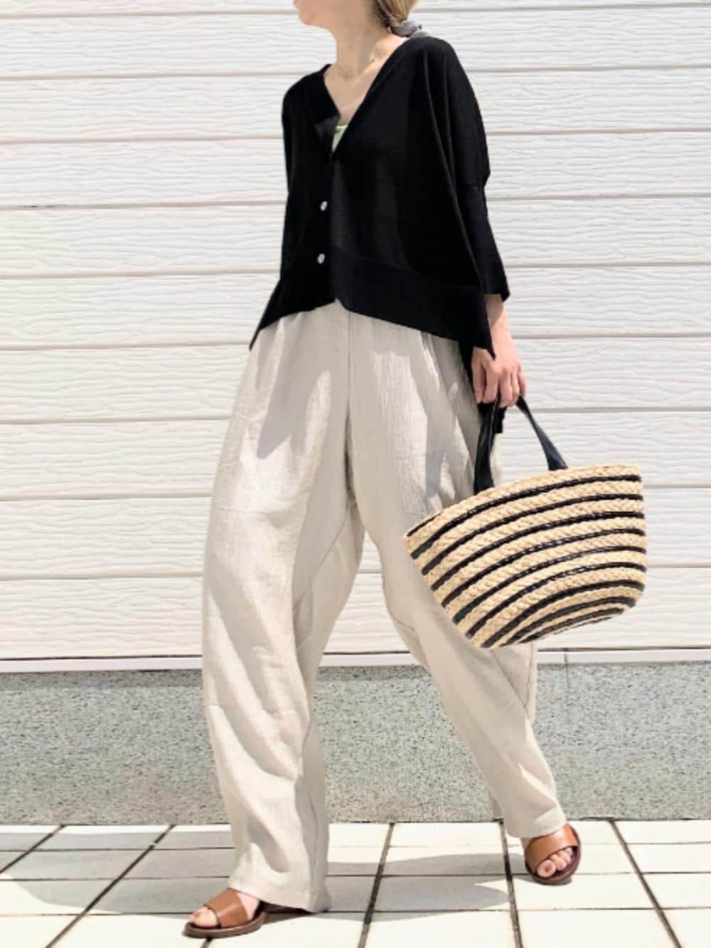 ベージュ系のその他パンツ、ブラック系のかごバッグ、ブラック系のカーディガン/ボレロを着用したレディースの春コーディネートの3枚目の写真