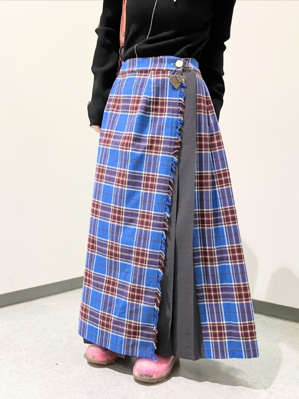 ブルー系のスカート、ブラック系のニット/セーター、ピンク系のボストンバッグを着用したレディースの秋コーディネートの3枚目の写真