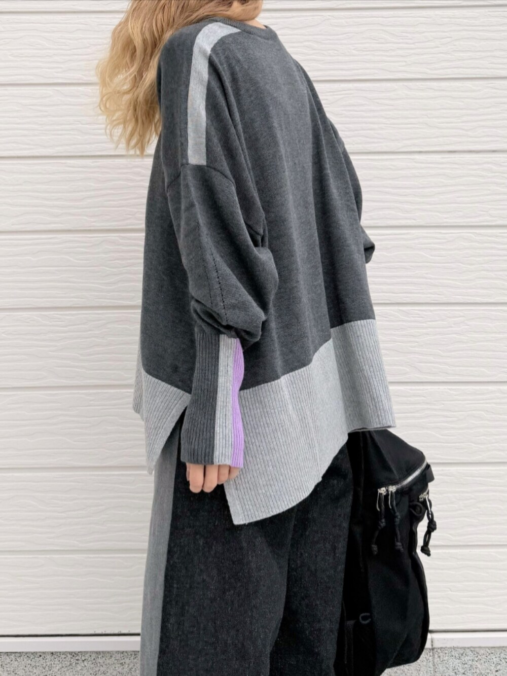 ブラック系のデニムパンツ、グレー系のニット/セーター、ブラック系のバックパック/リュックを着用したレディースの秋コーディネートの5枚目の写真