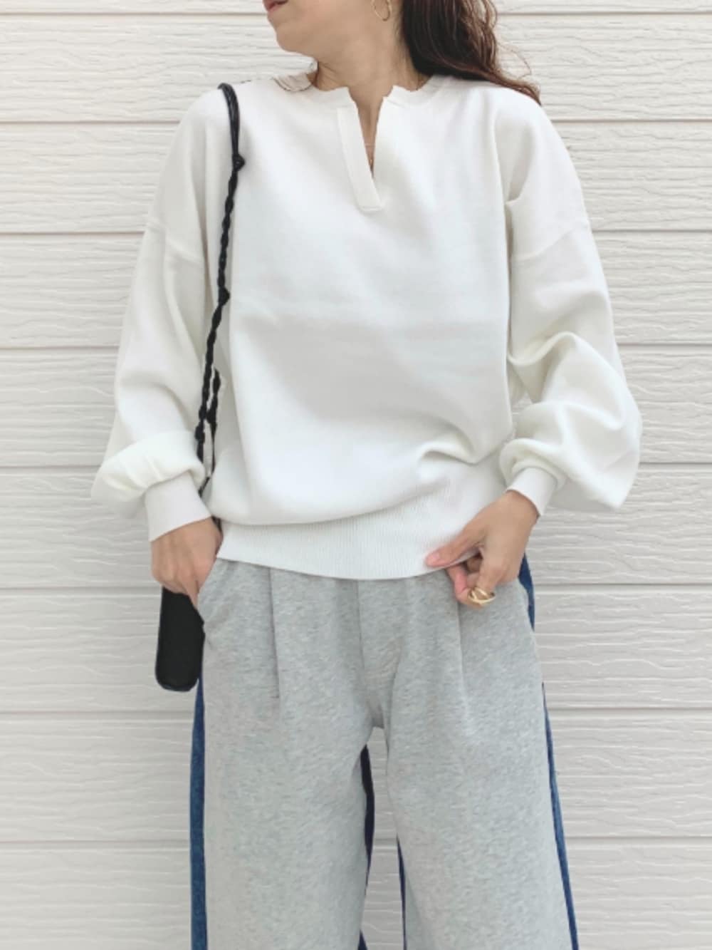 グレー系のデニムパンツ、ブラック系のショルダーバッグ、シルバー系のスニーカーを着用したレディースの冬コーディネートの3枚目の写真