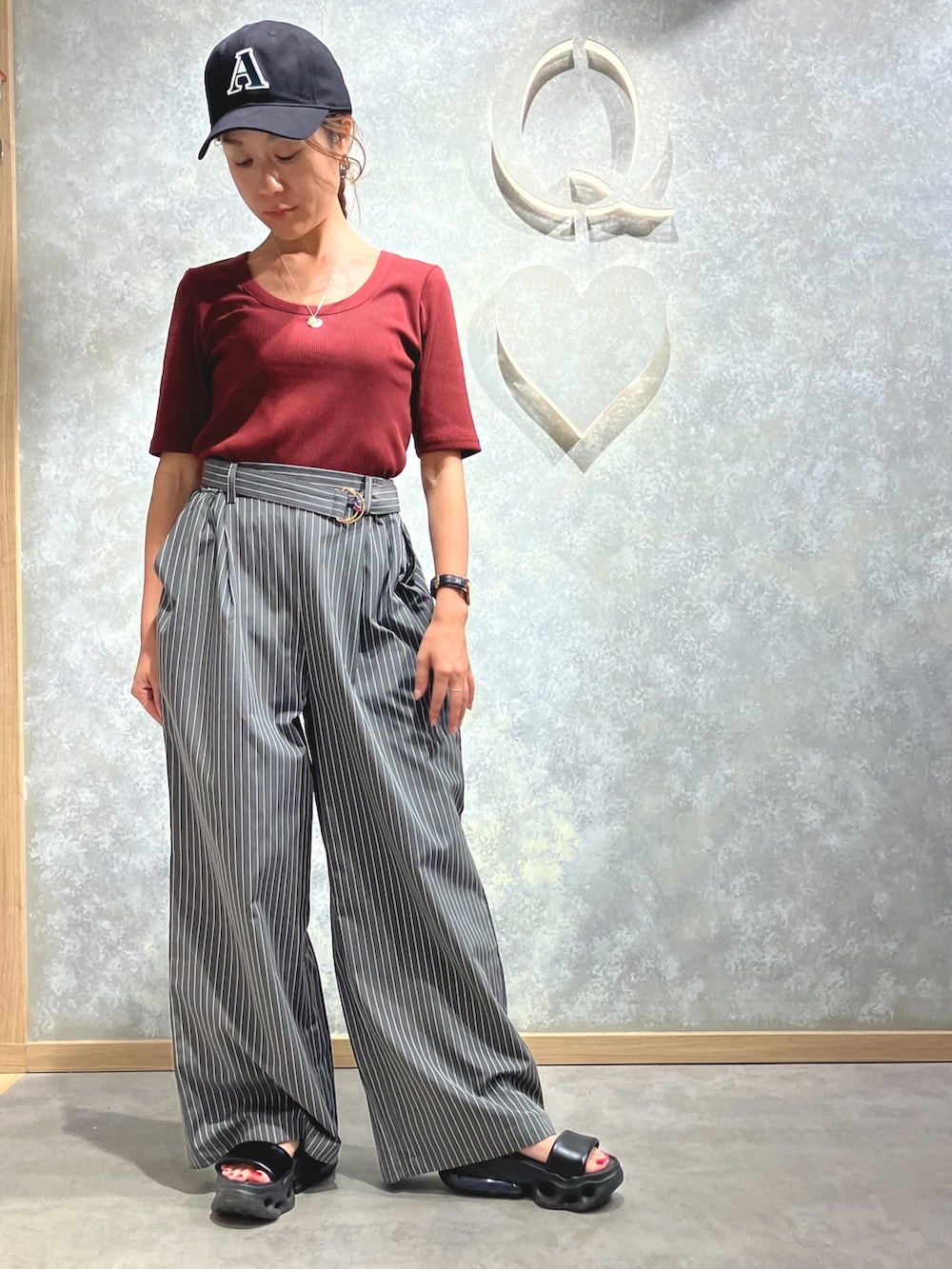 グレー系のその他パンツ、レッド系のTシャツ/カットソー、ゴールド系のネックレスを着用したレディースの夏コーディネートの2枚目の写真