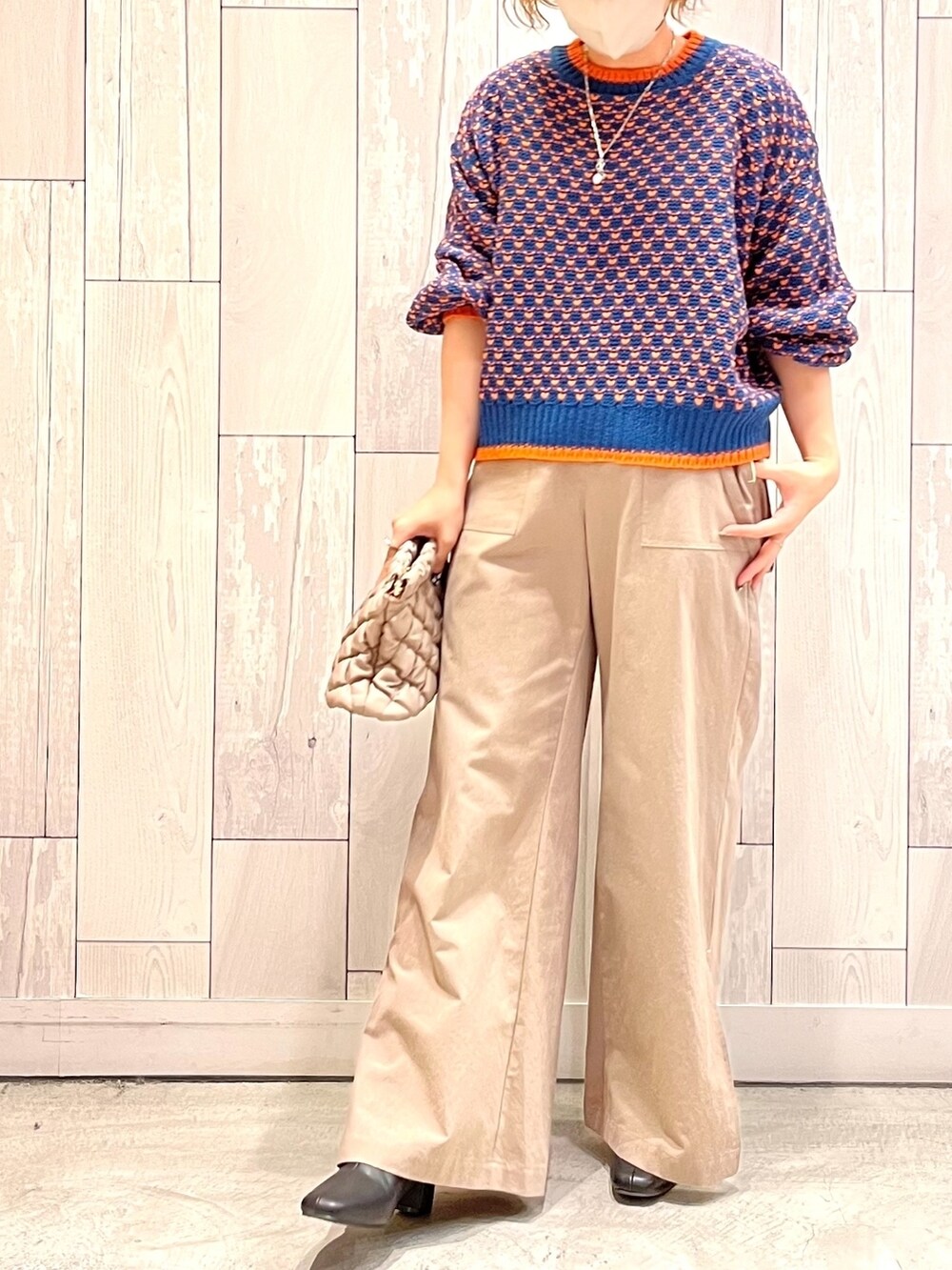 ベージュ系のショルダーバッグ、ベージュ系のその他パンツ、ブルー系のニット/セーターを着用したレディースの秋コーディネートの2枚目の写真