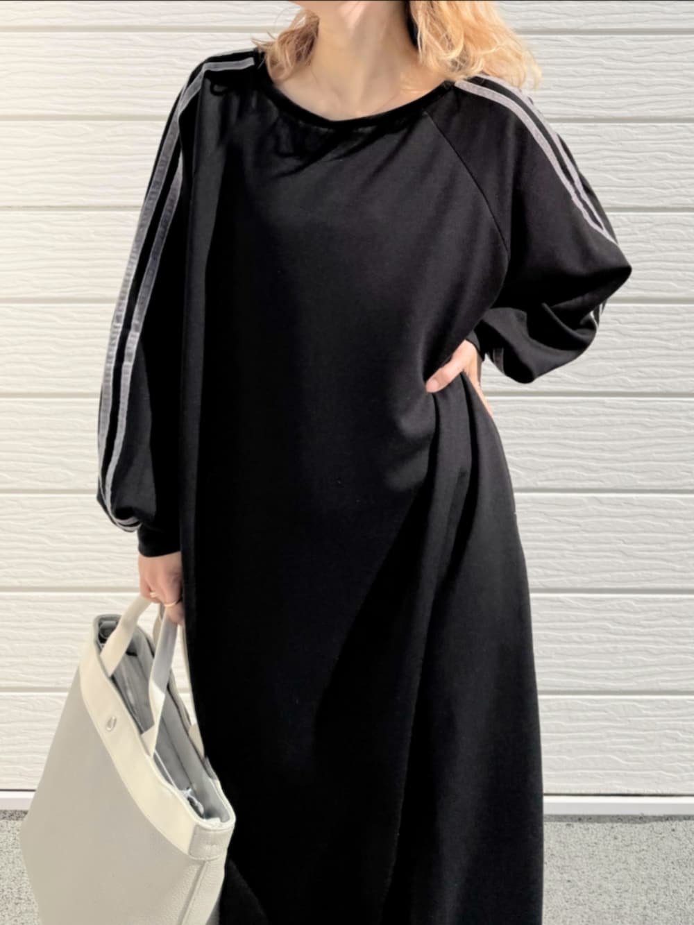 ホワイト系のスニーカー、ブラック系のワンピース、グレー系のトートバッグを着用したレディースの秋コーディネートの4枚目の写真