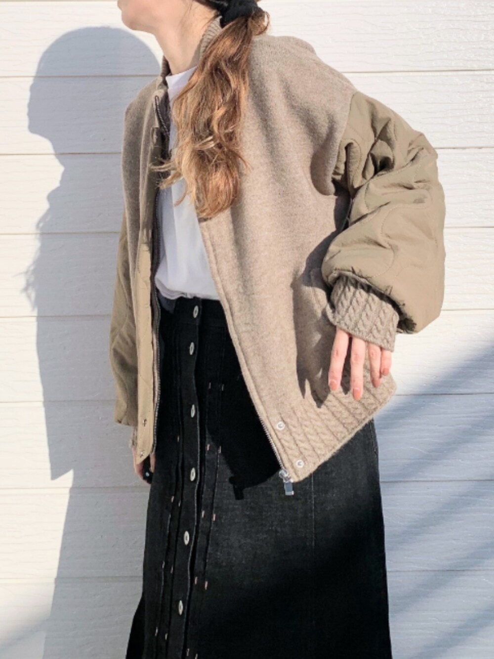 イエロー系のブルゾン、ホワイト系のTシャツ/カットソー、ブラック系のデニムスカートを着用したレディースの秋コーディネートの5枚目の写真
