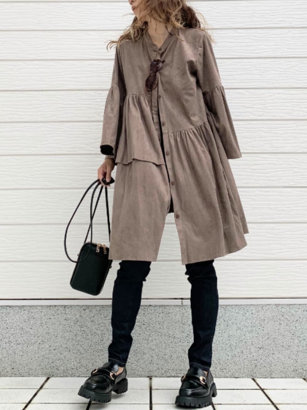 ブルー系のデニムパンツ、ブラック系のローファー、ブラック系のショルダーバッグを着用したレディースの秋コーディネートの3枚目の写真