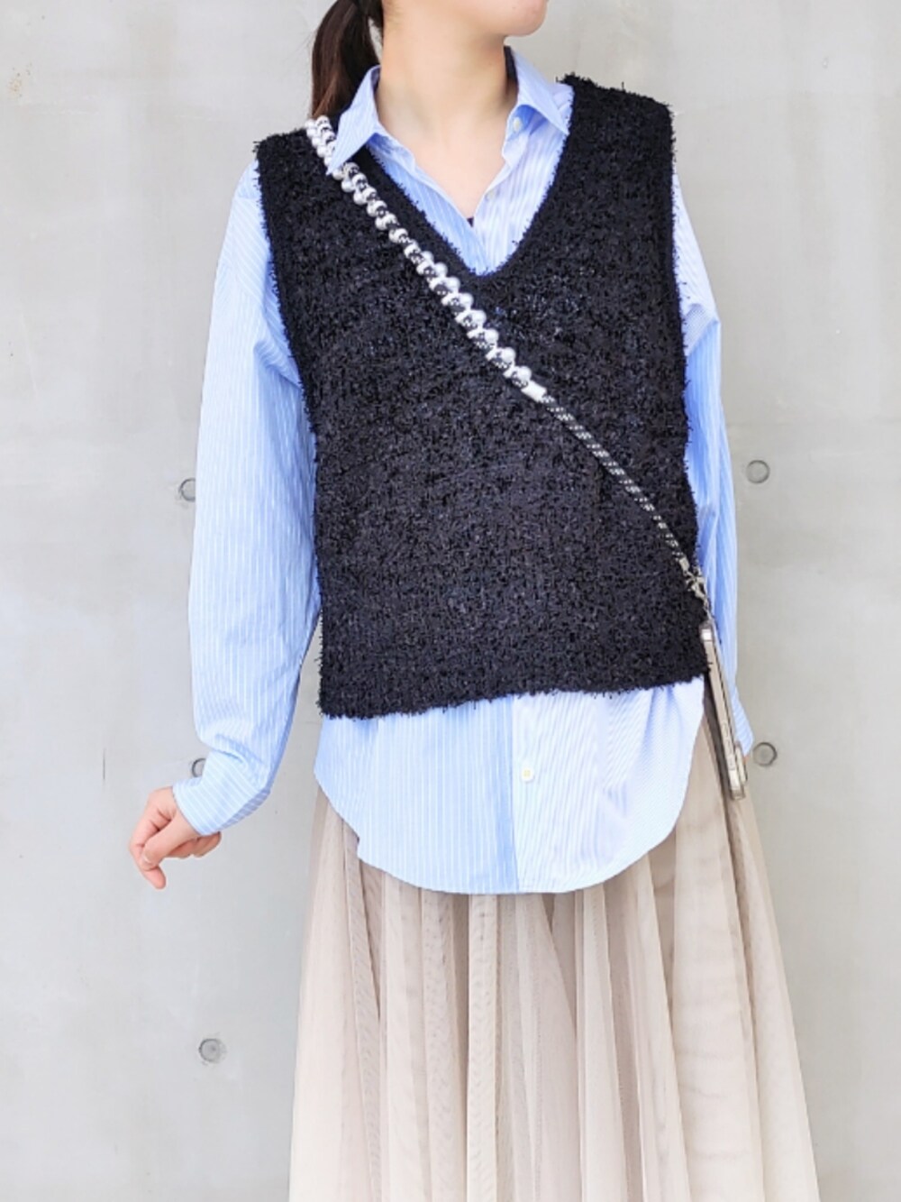 ゴールド系のスカート、グレー系のサンダル、ブルー系のシャツ/ブラウスを着用したレディースの冬コーディネートの3枚目の写真