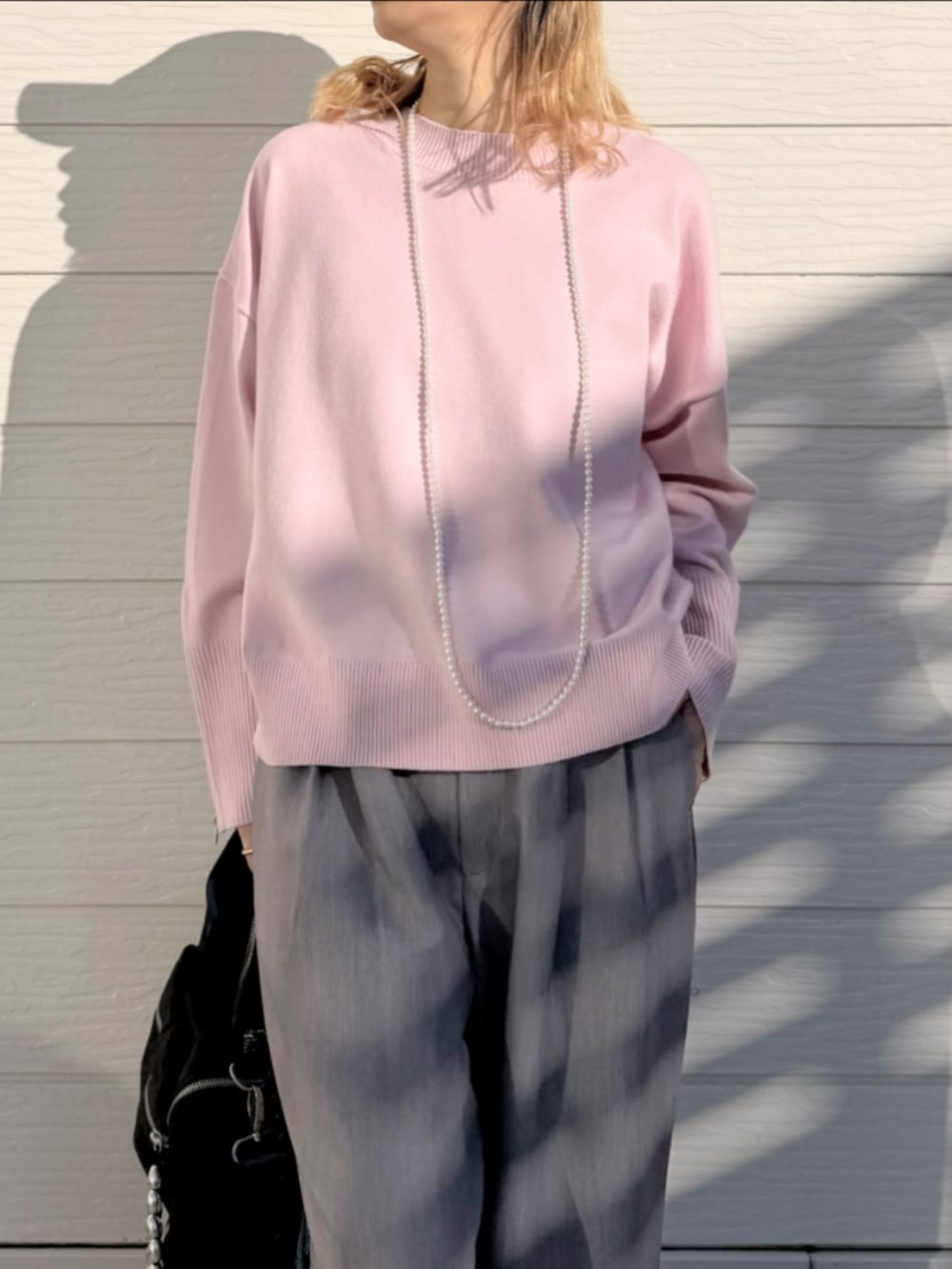 ホワイト系のスニーカー、グレー系のスラックス、ピンク系のニット/セーターを着用したレディースの冬コーディネートの3枚目の写真