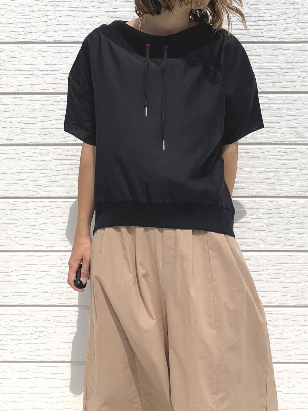 レッド系のショルダーバッグ、ベージュ系のその他パンツ、ブラック系のTシャツ/カットソーを着用したレディースの夏コーディネートの3枚目の写真