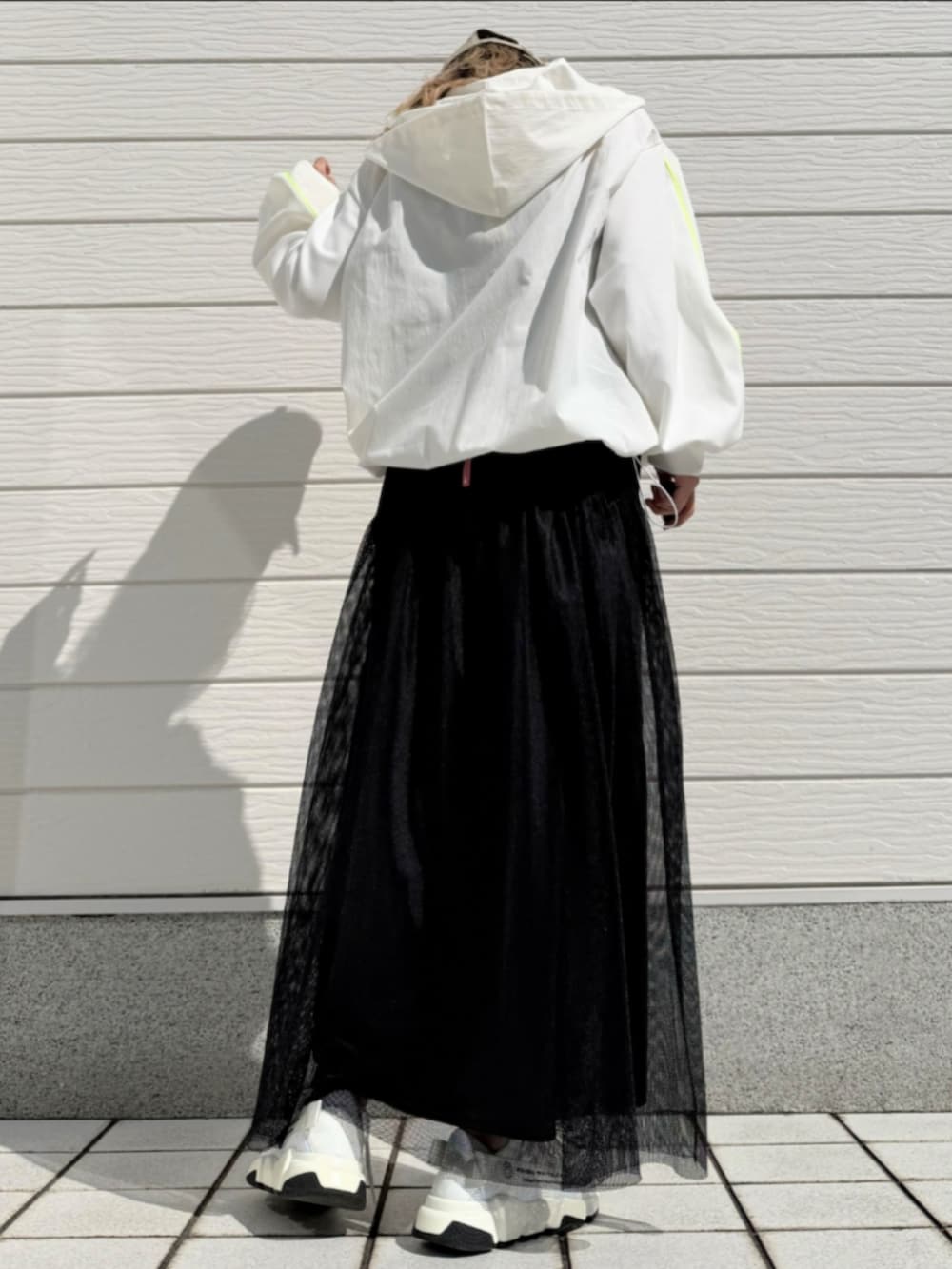 ブラック系のスカート、ブラック系のパーカーを着用したレディースの春コーディネートの3枚目の写真