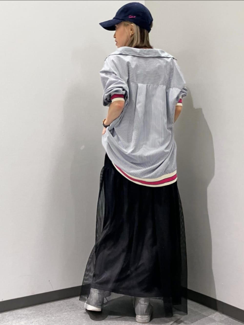 ブラック系のスカート、ブルー系のシャツ/ブラウス、ブルー系のキャップを着用したレディースの春コーディネートの3枚目の写真