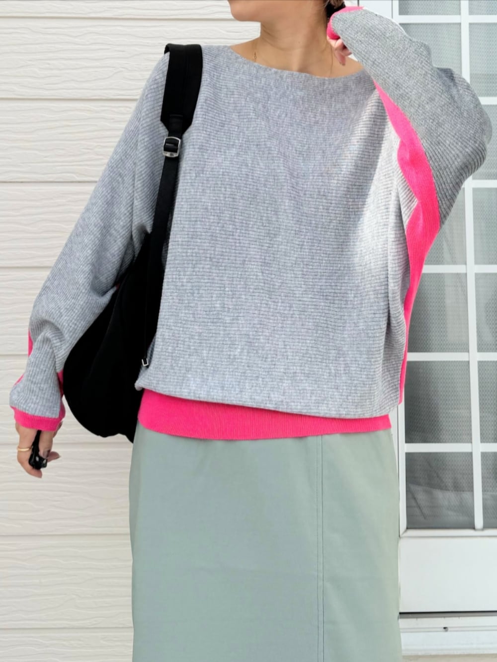 グリーン系のスカート、ブラック系のバックパック/リュック、グレー系のニット/セーターを着用したレディースの秋コーディネートの3枚目の写真