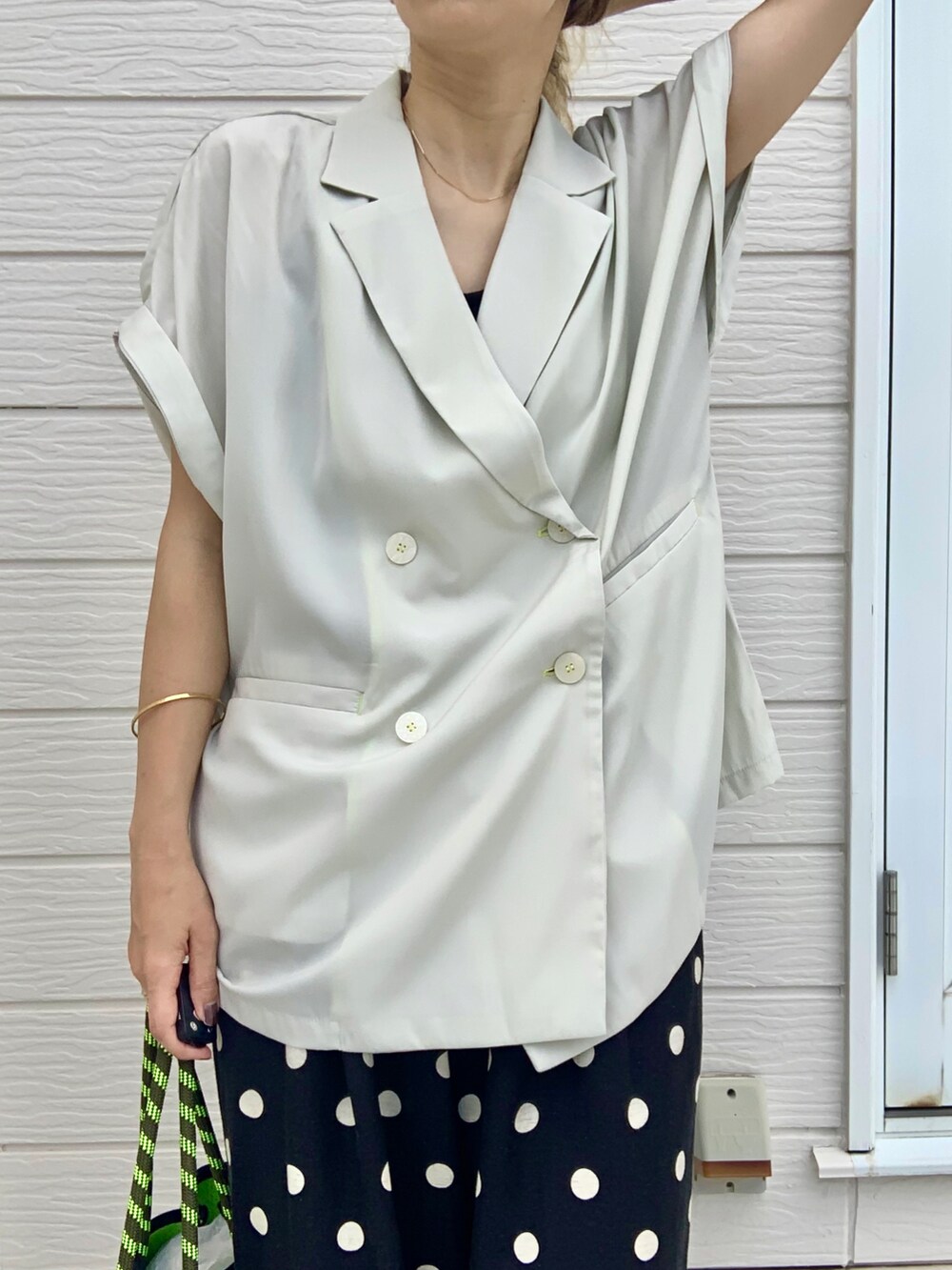 グレー系のトートバッグ、ブラック系のその他パンツ、ベージュ系のテーラードジャケットを着用したレディースの夏コーディネートの3枚目の写真