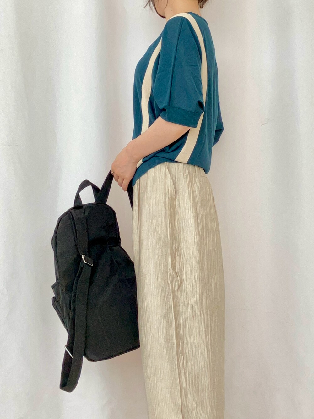 ブルー系のニット/セーター、ベージュ系のその他パンツ、グレー系のサンダルを着用したレディースの夏コーディネートの4枚目の写真