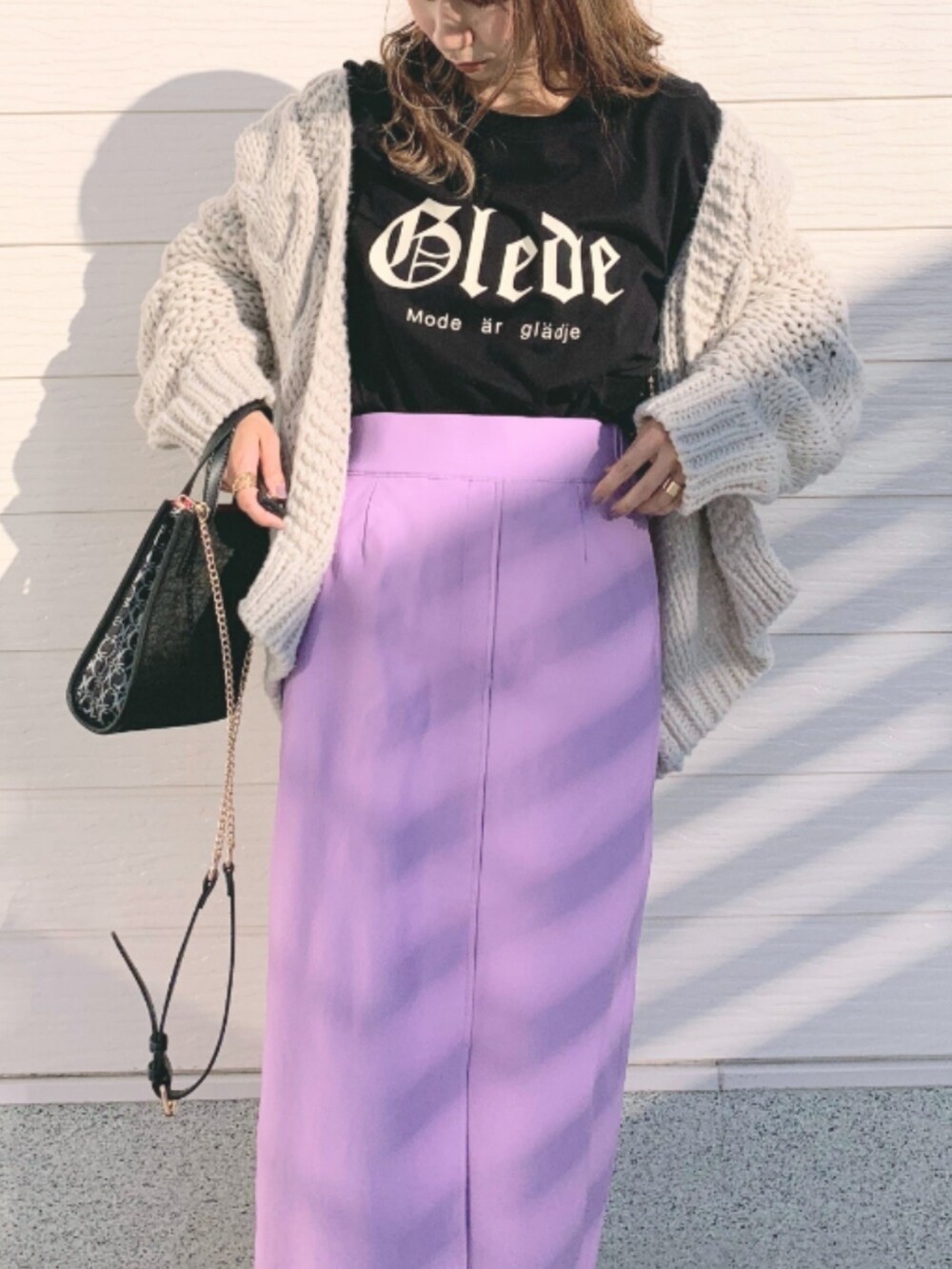 パープル系のスカート、ブラック系のショルダーバッグ、グレー系のカーディガン/ボレロを着用したレディースの秋コーディネートの3枚目の写真