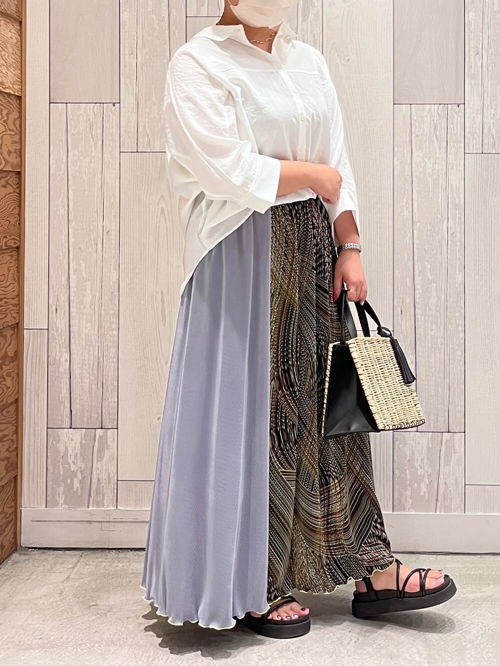 グリーン系のスカート、ホワイト系のシャツ/ブラウス、ブラック系のかごバッグを着用したレディースの夏コーディネートの2枚目の写真