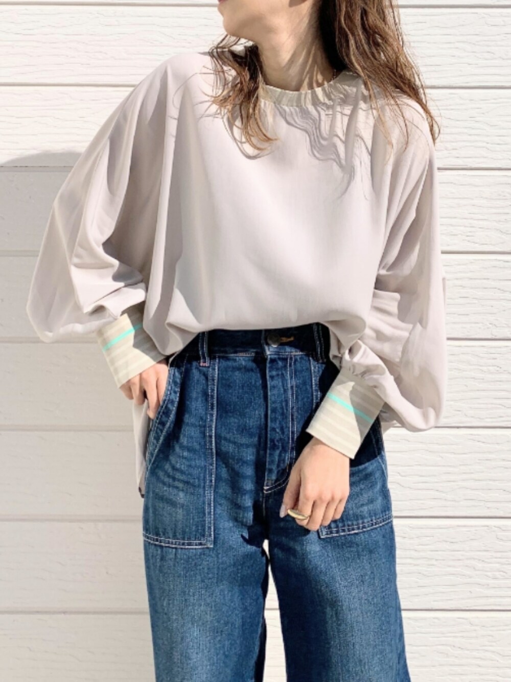 ブルー系のデニムパンツ、ホワイト系のスニーカー、ベージュ系のシャツ/ブラウスを着用したレディースの冬コーディネートの5枚目の写真