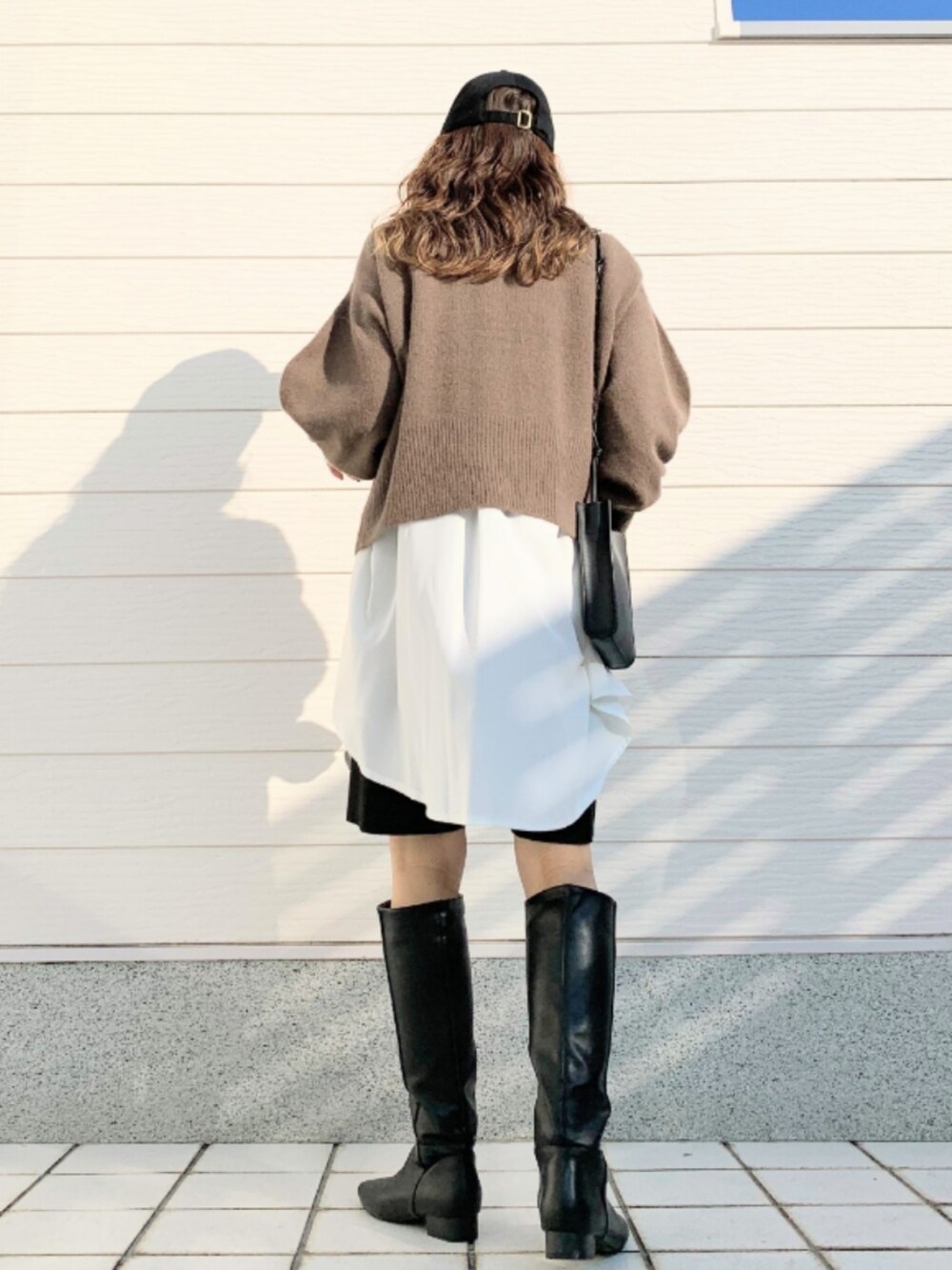 ブラウン系のニット/セーター、ホワイト系のシャツ/ブラウス、グレー系のその他パンツを着用したレディースの冬コーディネートの4枚目の写真