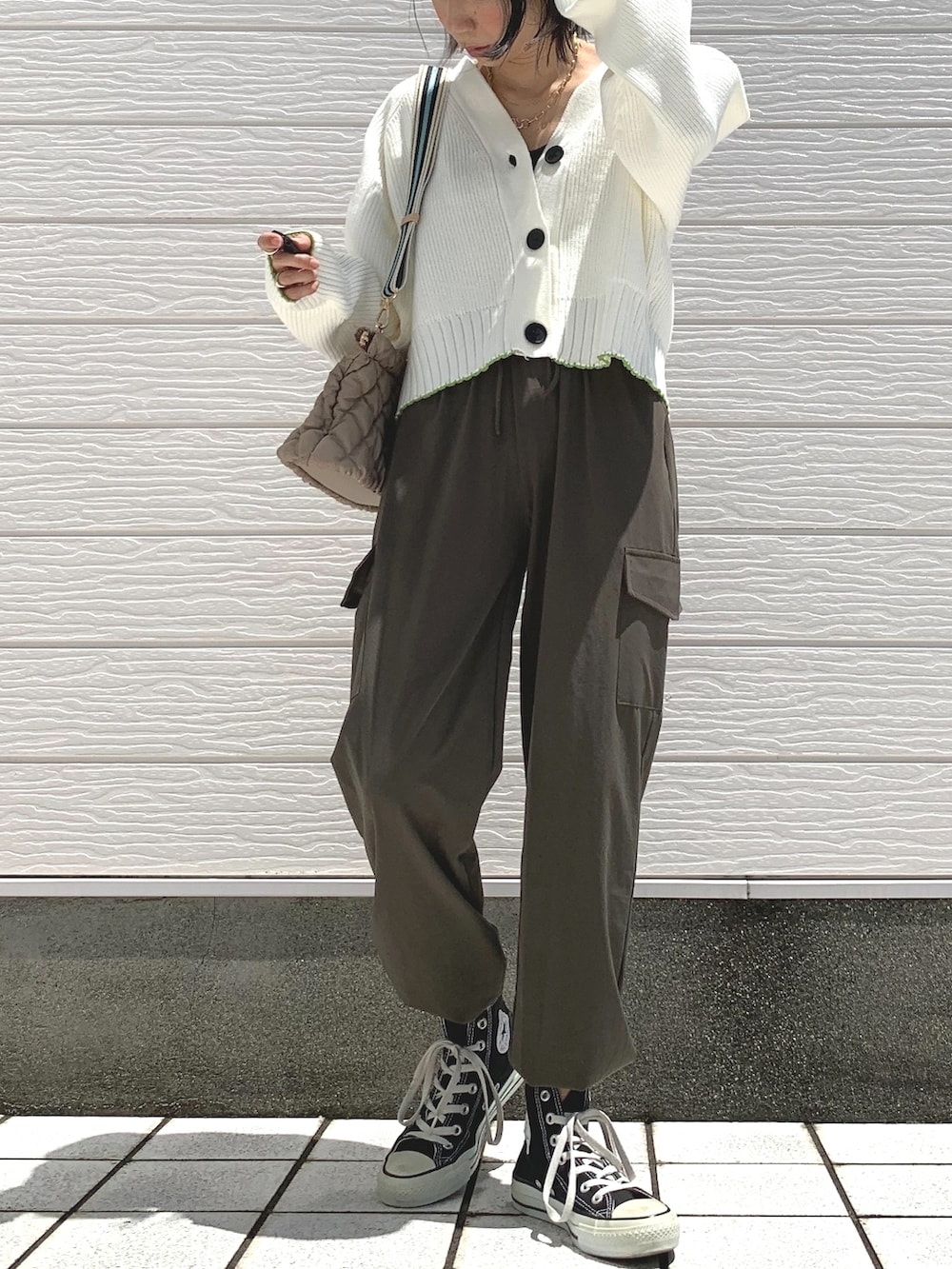 グリーン系のカーゴパンツ、ブラック系のスニーカー、ホワイト系のカーディガン/ボレロを着用したレディースの夏コーディネートの2枚目の写真