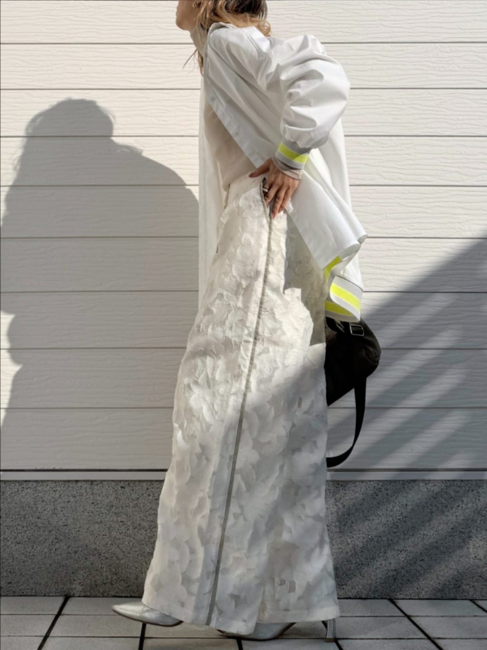 グリーン系のボストンバッグ、ホワイト系のTシャツ/カットソー、ホワイト系のシャツ/ブラウスを着用したレディースの冬コーディネートの2枚目の写真