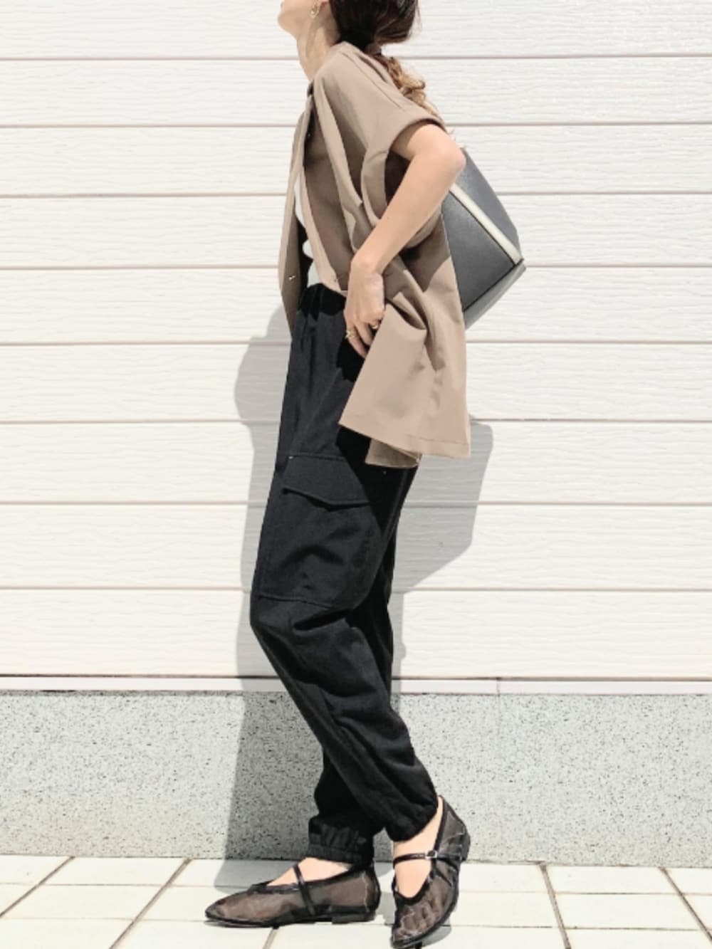 ブラック系のパンプス、ブラック系のカーゴパンツ、ベージュ系のテーラードジャケットを着用したレディースの春コーディネートの3枚目の写真