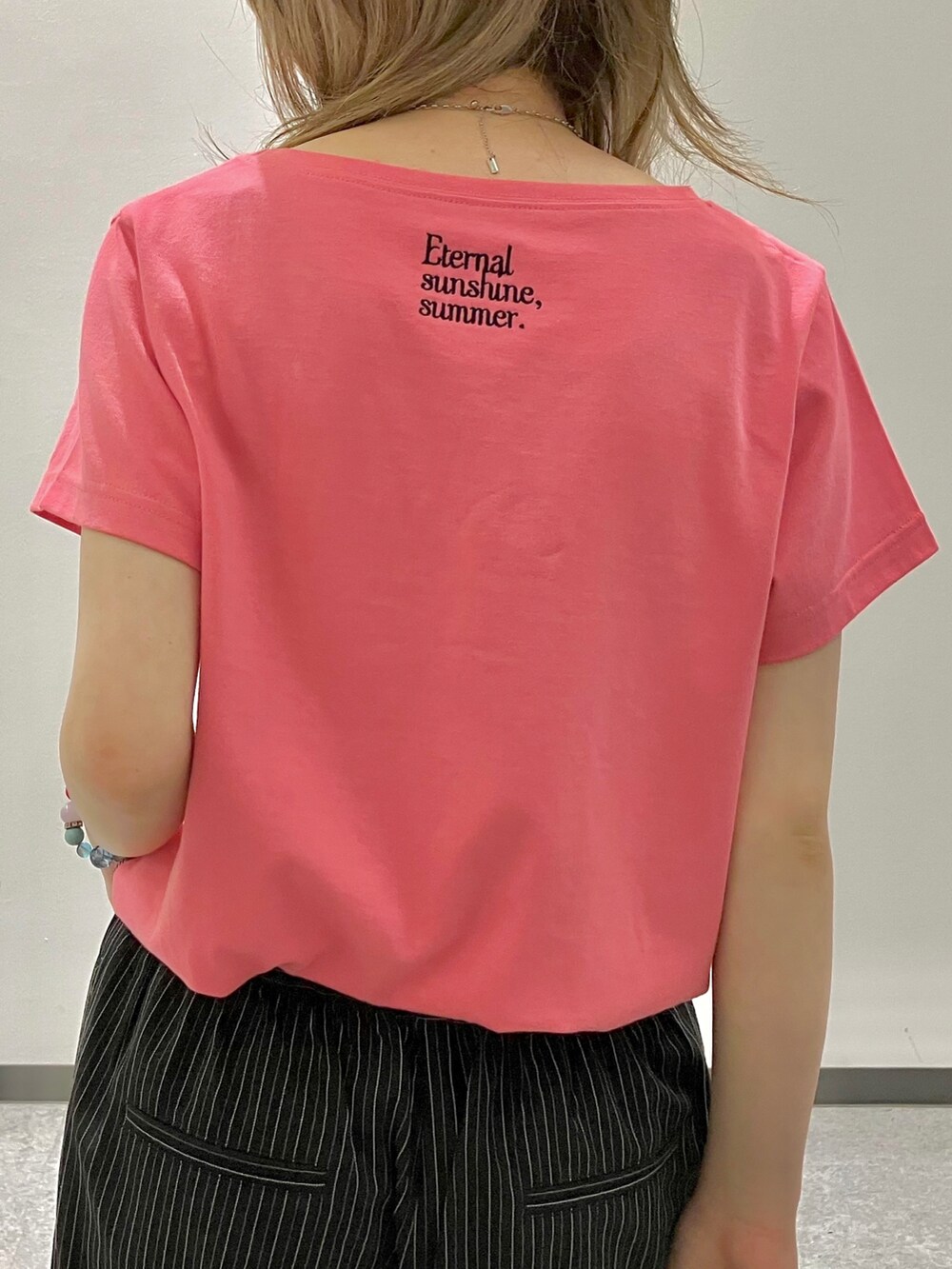 ピンク系のTシャツ/カットソー、ブラック系のスラックス、ブラック系のボストンバッグを着用したレディースの夏コーディネートの5枚目の写真