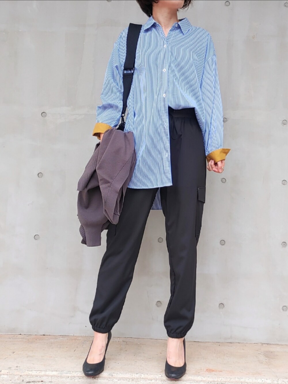 ブラック系のカーゴパンツ、グレー系のカーディガン/ボレロ、ブラック系のクラッチバッグを着用したレディースの秋コーディネートの3枚目の写真