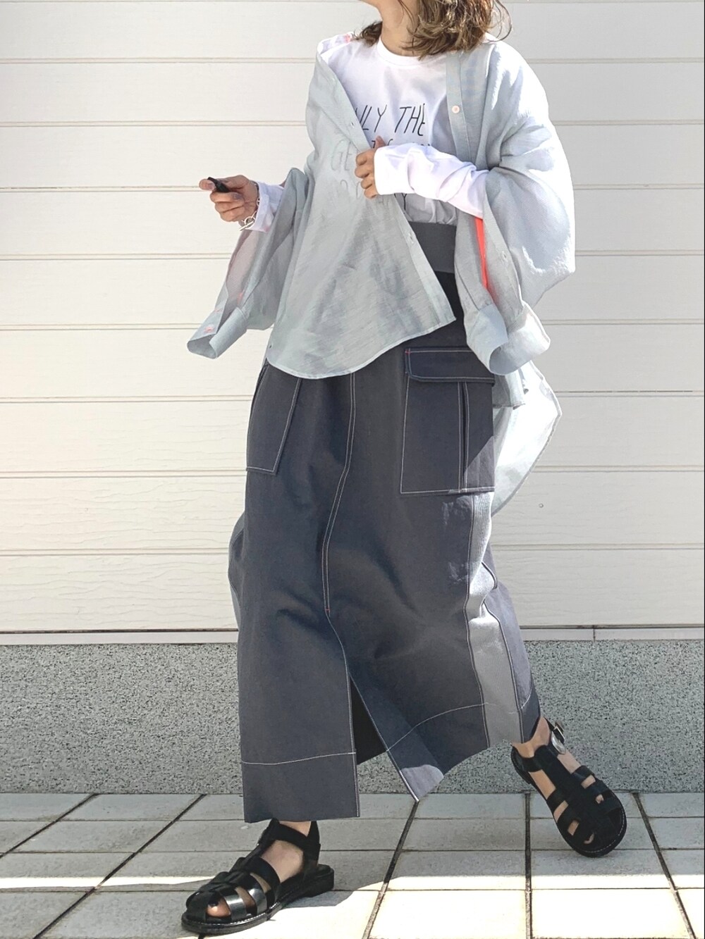 ブラック系のサンダル、ホワイト系のTシャツ/カットソー、グレー系のシャツ/ブラウスを着用したレディースの春コーディネートの2枚目の写真