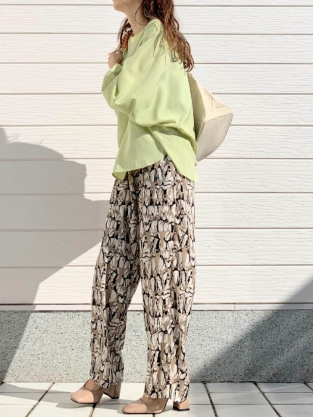 イエロー系のシャツ/ブラウス、ホワイト系のトートバッグ、ブラウン系のその他パンツを着用したレディースの冬コーディネートの2枚目の写真