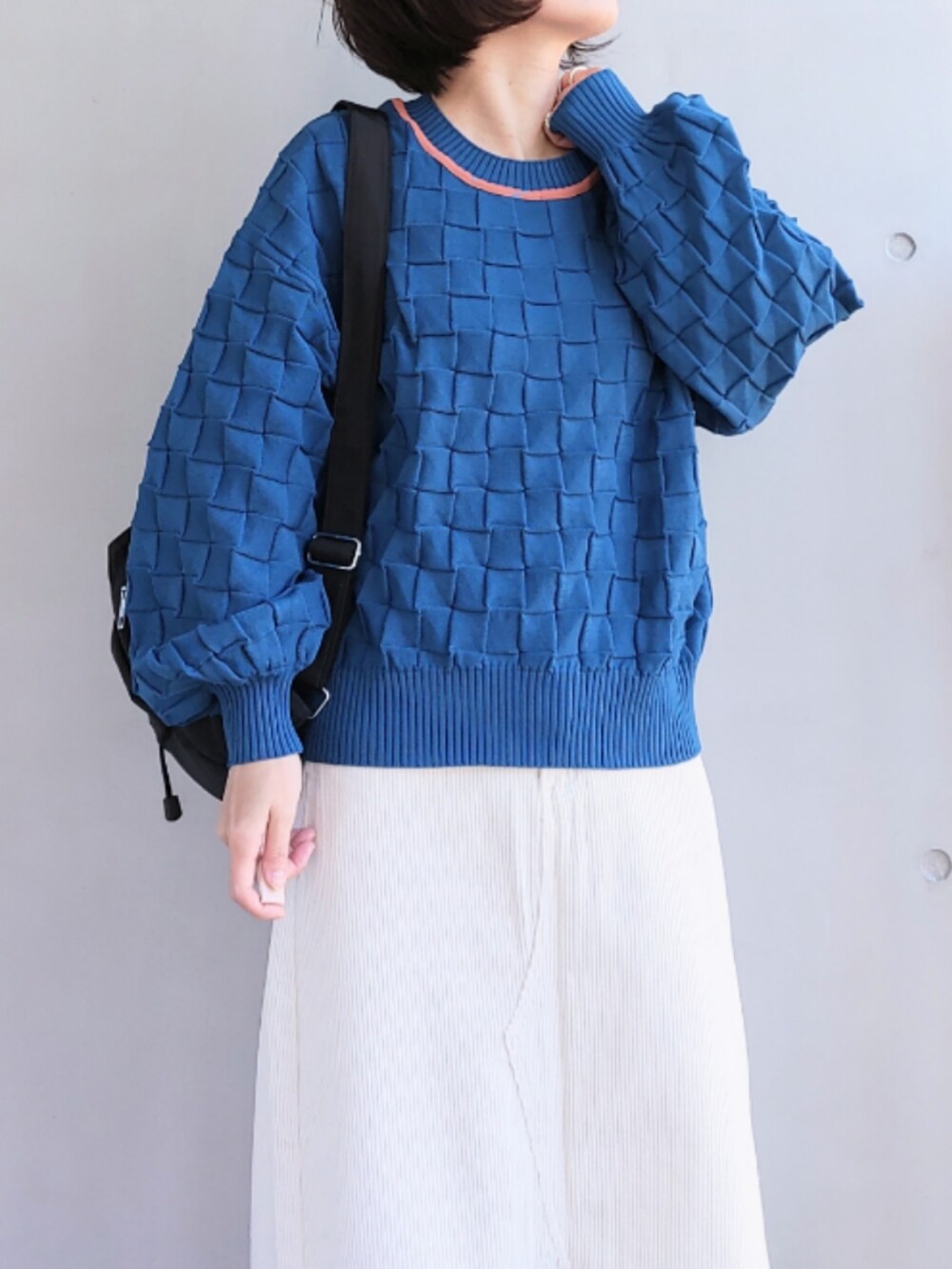 ブラック系のバックパック/リュック、ホワイト系のスカート、ブラック系のスニーカーを着用したレディースの冬コーディネートの4枚目の写真