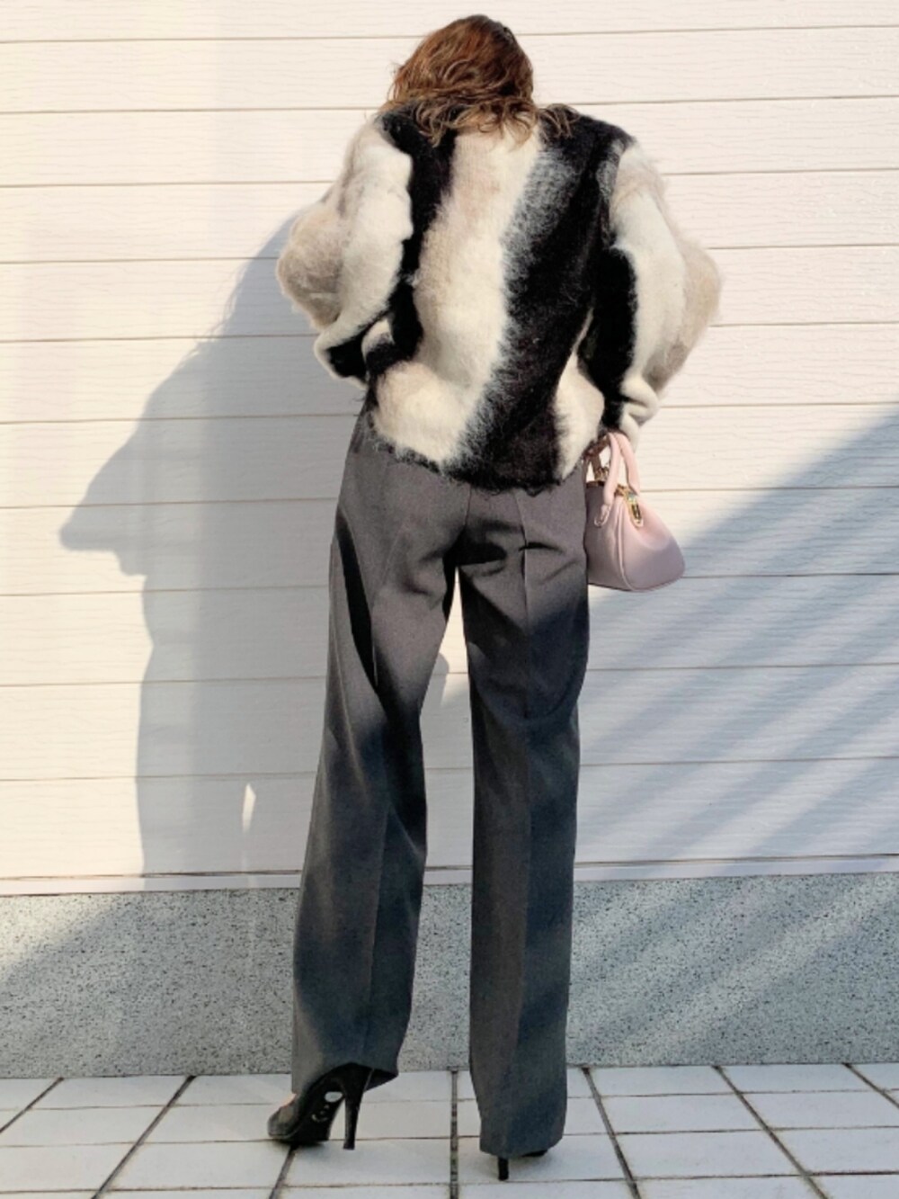 ブラック系のニット/セーター、ピンク系のショルダーバッグ、グレー系のその他パンツを着用したレディースの秋コーディネートの3枚目の写真