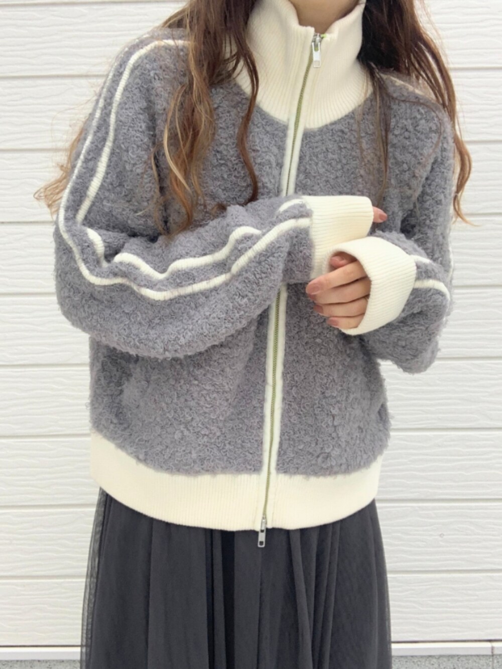 ブラック系のスカート、シルバー系のスニーカー、グレー系のカーディガン/ボレロを着用したレディースの秋コーディネートの4枚目の写真