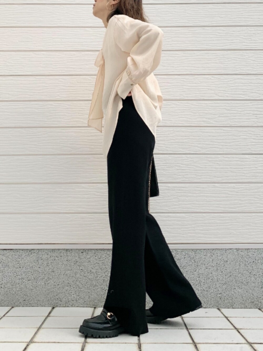 ブラック系のショルダーバッグ、ブラック系のローファー、ホワイト系のシャツ/ブラウスを着用したレディースの冬コーディネートの3枚目の写真