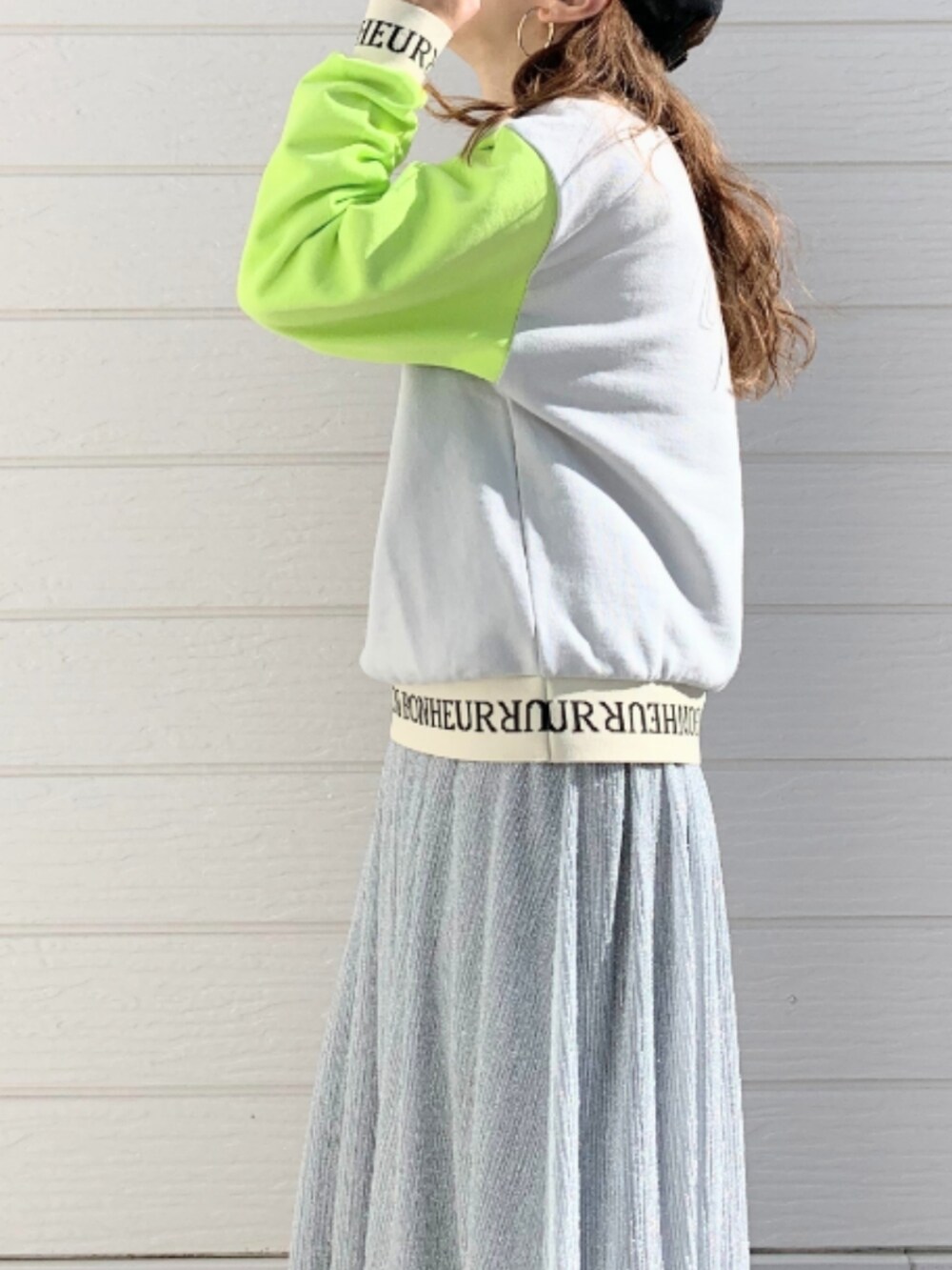 シルバー系のスカート、ホワイト系のスニーカー、グレー系のスウェットを着用したレディースの冬コーディネートの5枚目の写真