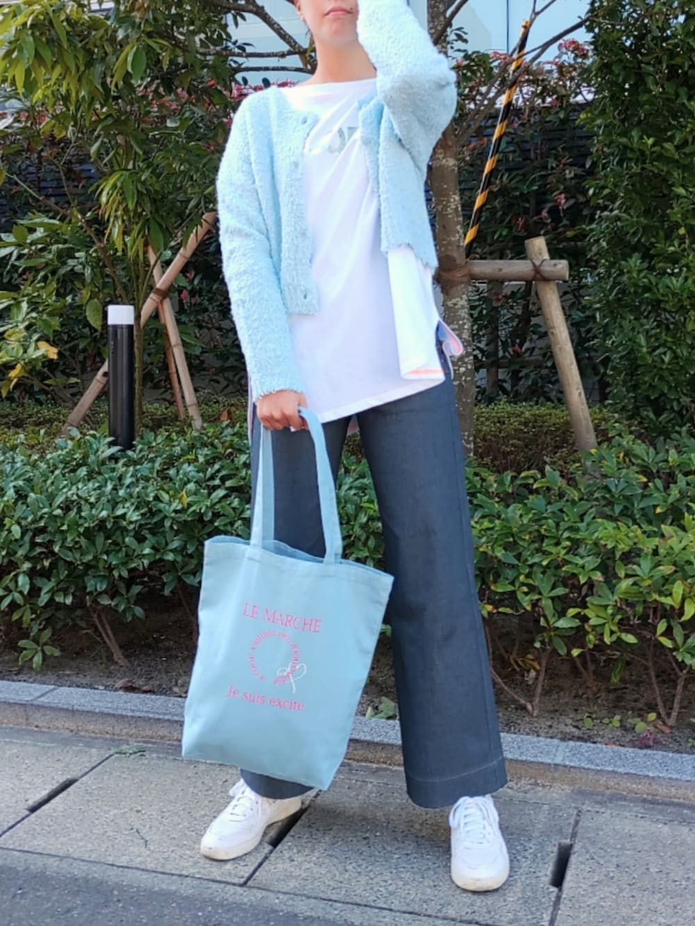 グレー系のデニムパンツ、ホワイト系のスニーカー、ブルー系のカーディガン/ボレロを着用したレディースの秋コーディネートの2枚目の写真