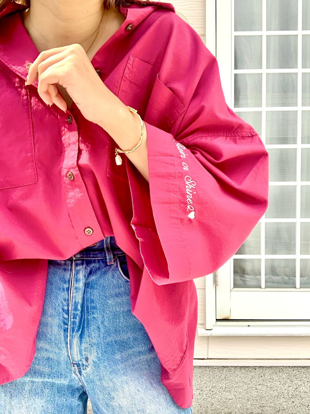 レッド系のシャツ/ブラウス、ブルー系のデニムパンツ、ゴールド系のブレスレットを着用したレディースの夏コーディネートの4枚目の写真