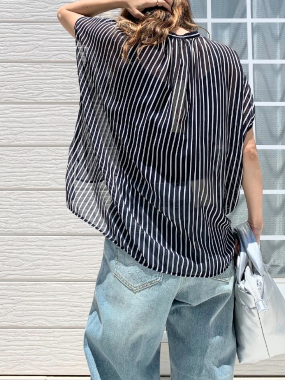 シルバー系のショルダーバッグ、ブルー系のデニムパンツ、ブルー系のシャツ/ブラウスを着用したレディースの夏コーディネートの5枚目の写真