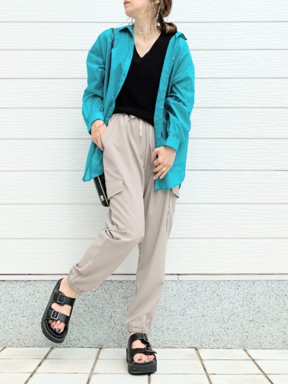 ブラック系のサンダル、ベージュ系のカーゴパンツ、ブラック系のショルダーバッグを着用したレディースの春コーディネートの2枚目の写真