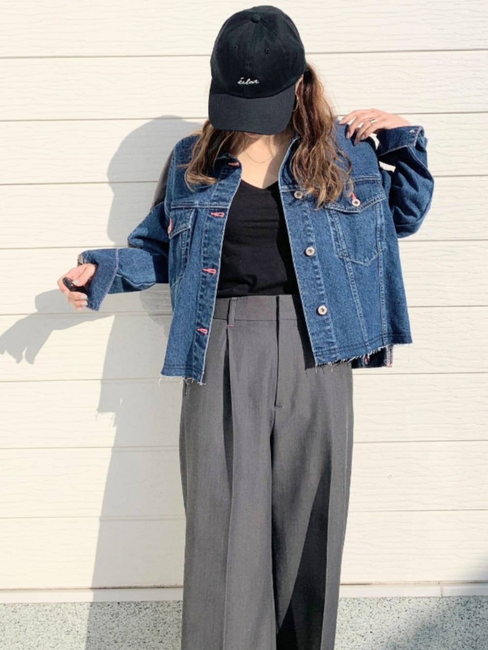 グレー系のスラックス、ブルー系のデニムジャケット、ブラック系のキャミソールを着用したレディースの冬コーディネートの4枚目の写真