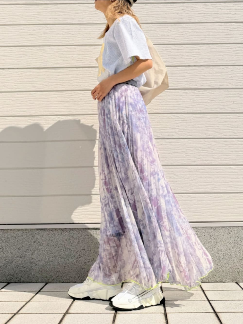 グレー系のTシャツ/カットソー、ホワイト系のトートバッグ、パープル系のスカートを着用したレディースの春コーディネートの2枚目の写真