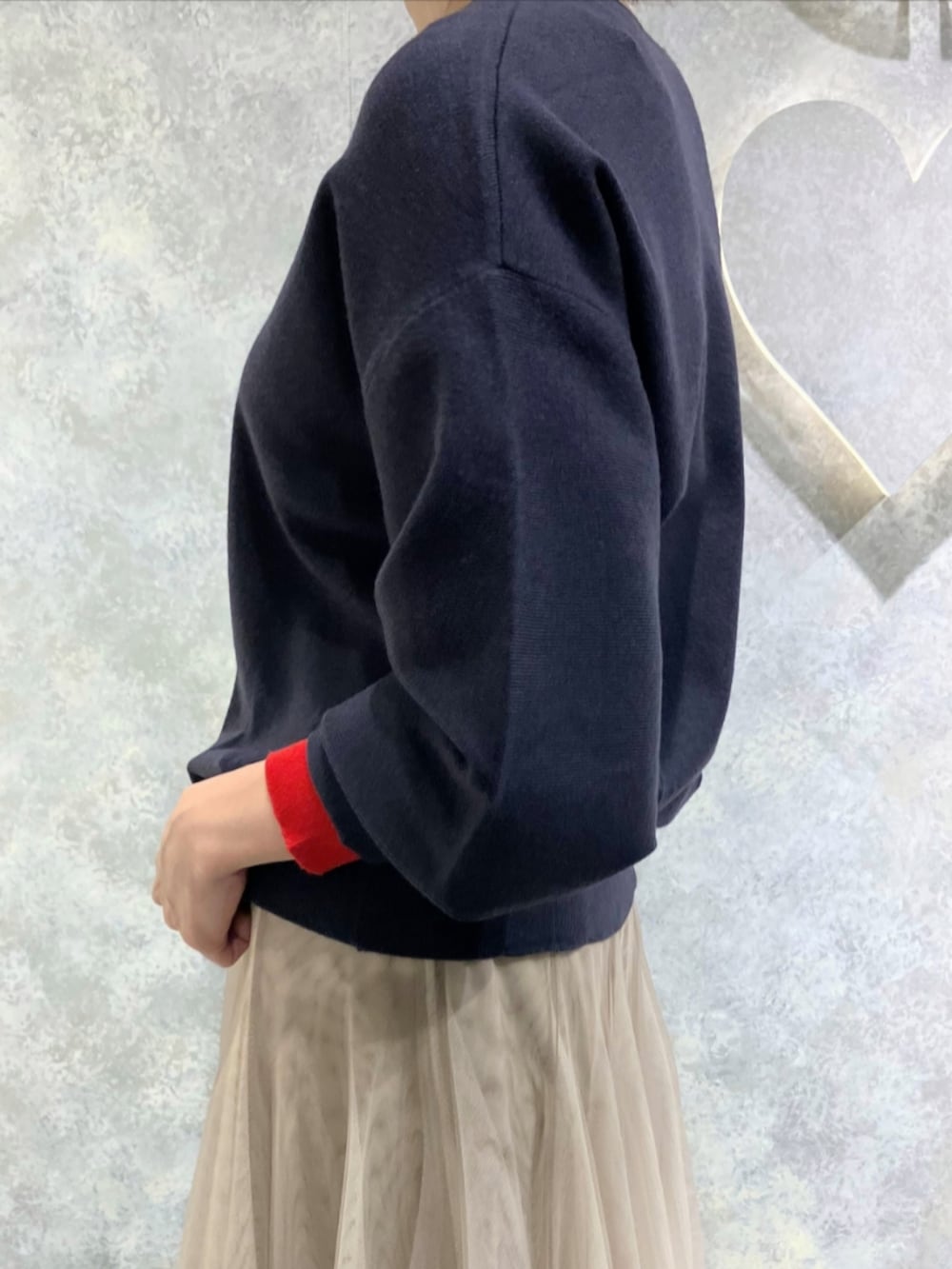 ゴールド系のスカート、レッド系のトートバッグ、ブルー系のニット/セーターを着用したレディースの秋コーディネートの5枚目の写真