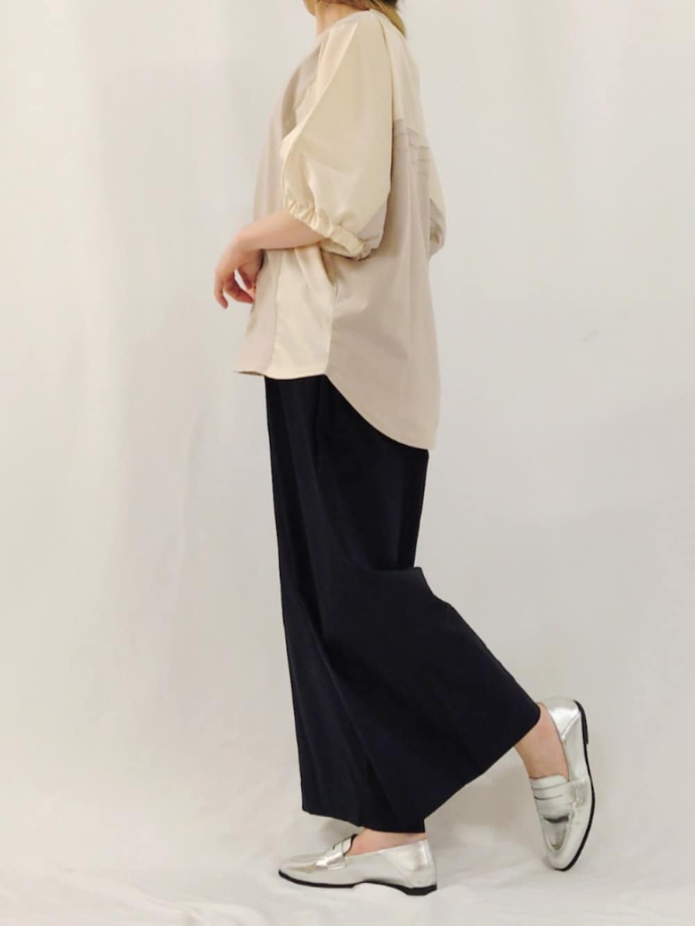 ブルー系のスラックス、シルバー系のローファー、ベージュ系のTシャツ/カットソーを着用したレディースの春コーディネートの4枚目の写真