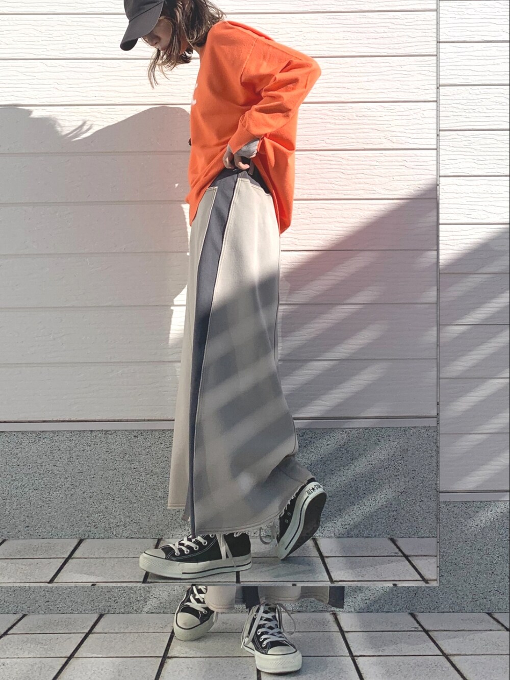 ベージュ系のスカート、オレンジ系のニット/セーター、ブラック系のスニーカーを着用したレディースの冬コーディネートの3枚目の写真