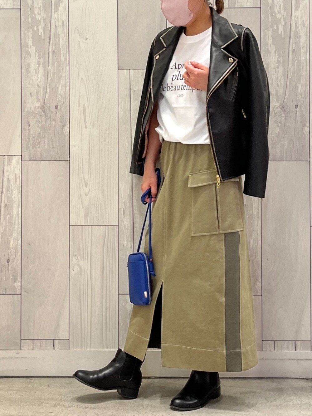 ブラック系のライダースジャケット、ホワイト系のTシャツ/カットソー、ブルー系のショルダーバッグを着用したレディースの冬コーディネートの2枚目の写真