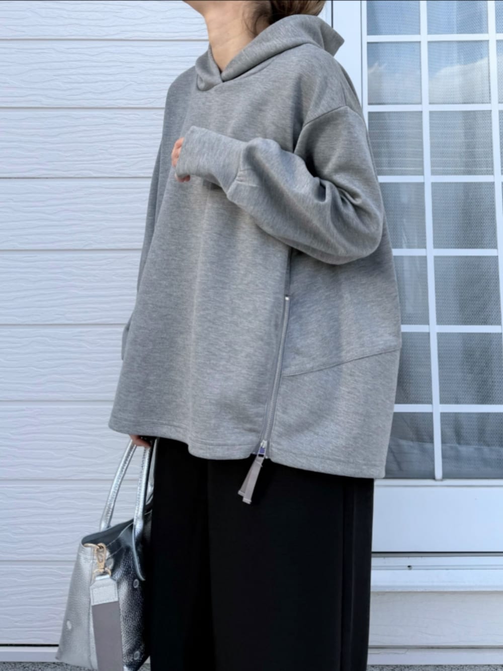 シルバー系のトートバッグ、ブラック系のその他パンツ、グレー系のパーカーを着用したレディースの冬コーディネートの5枚目の写真