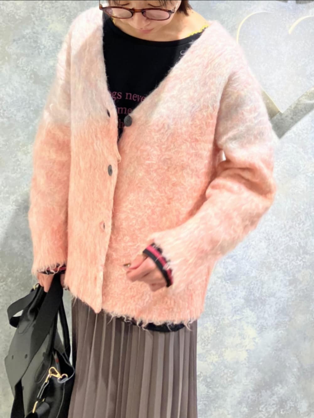 グリーン系のスカート、ブラック系のトートバッグ、ブラック系のTシャツ/カットソーを着用したレディースの冬コーディネートの4枚目の写真