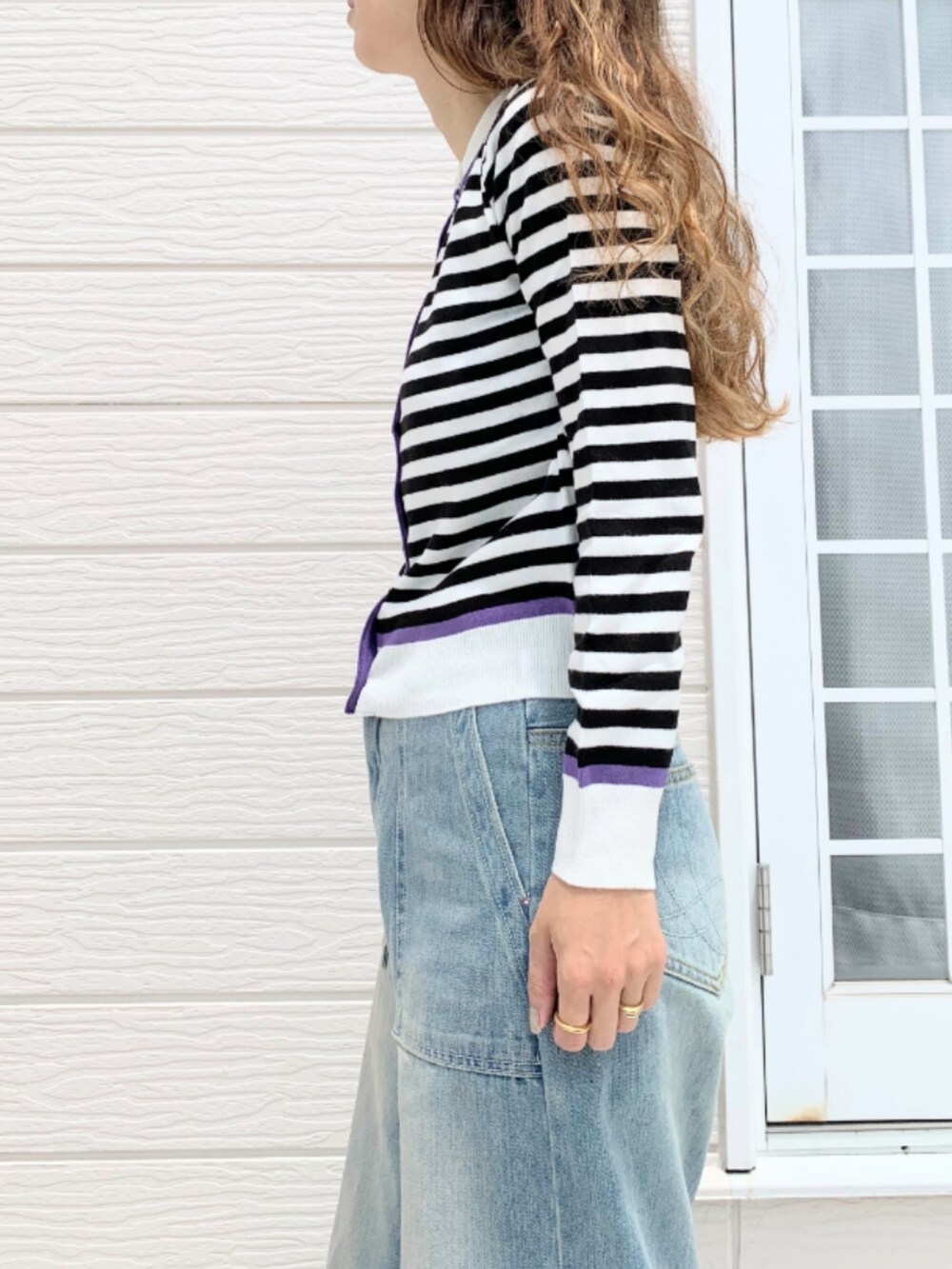 ブルー系のデニムパンツ、ホワイト系のボストンバッグ、ホワイト系のカーディガン/ボレロを着用したレディースの夏コーディネートの5枚目の写真