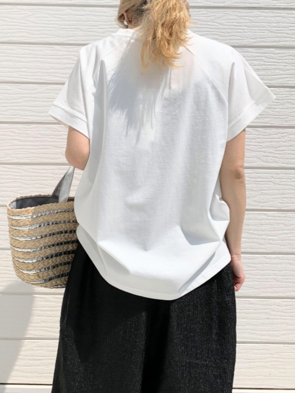 シルバー系のかごバッグ、ブラック系のその他パンツ、ホワイト系のTシャツ/カットソーを着用したレディースの春コーディネートの4枚目の写真