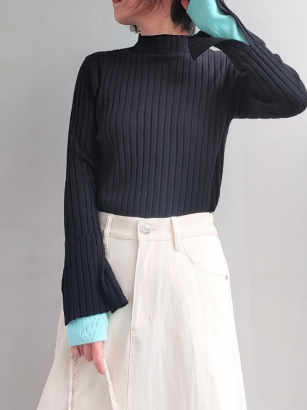 ブルー系のトートバッグ、ホワイト系のデニムスカート、ブラック系のスニーカーを着用したレディースの冬コーディネートの5枚目の写真